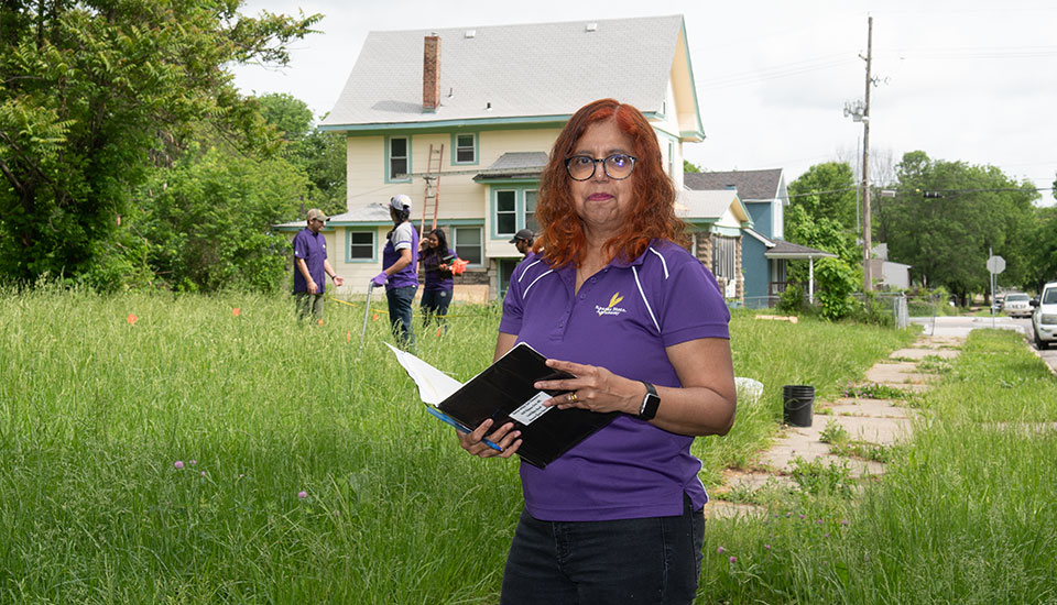 Woman holding notebook in foreground with students in background