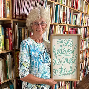 Barb Rathbun standing in front of shelves filled with cookbooks