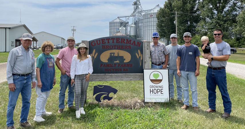 Family of Paul and Rosie Guetterman standing near farm sign