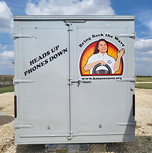 back end of food truck, image of girl smiling and waving