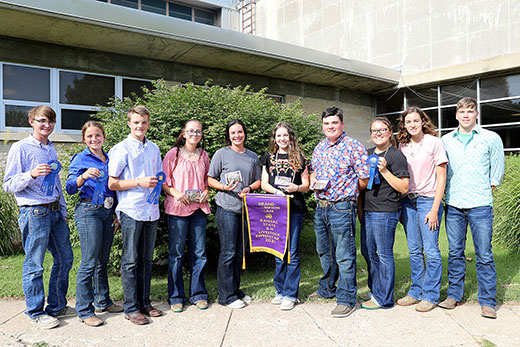 youth standing with award for champion team