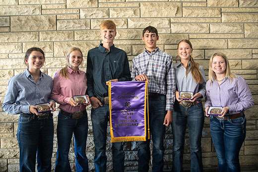 Six 4-H members standing and holding team awards