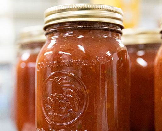 Sealed glass jar filled with hot sauce